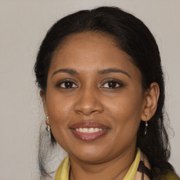 Joyful black adult female with medium  brown hair and brown eyes