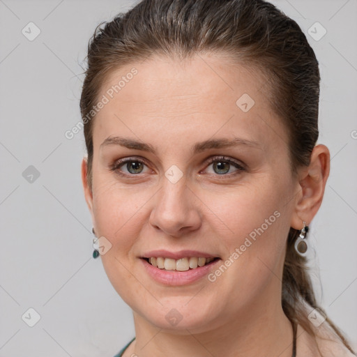 Joyful white young-adult female with short  brown hair and grey eyes