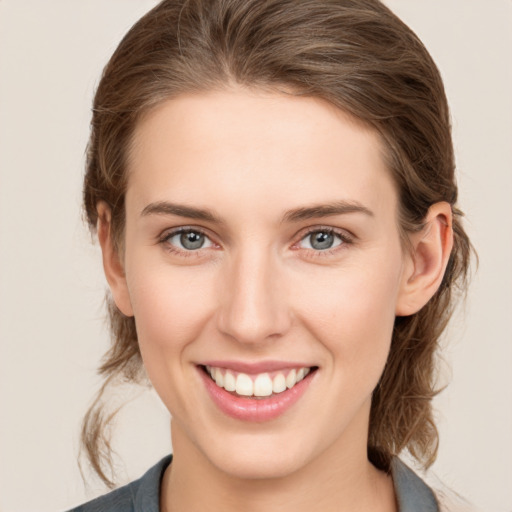 Joyful white young-adult female with medium  brown hair and grey eyes