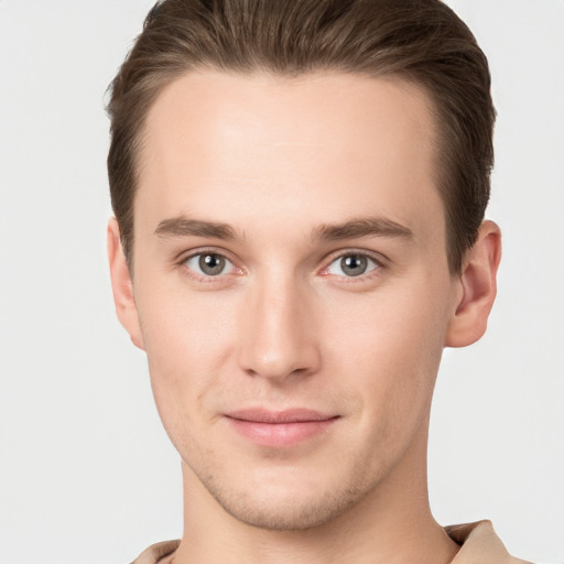 Joyful white young-adult male with short  brown hair and grey eyes