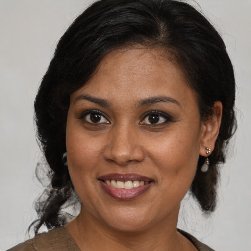Joyful black young-adult female with medium  brown hair and brown eyes