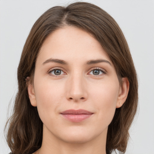 Joyful white young-adult female with medium  brown hair and grey eyes