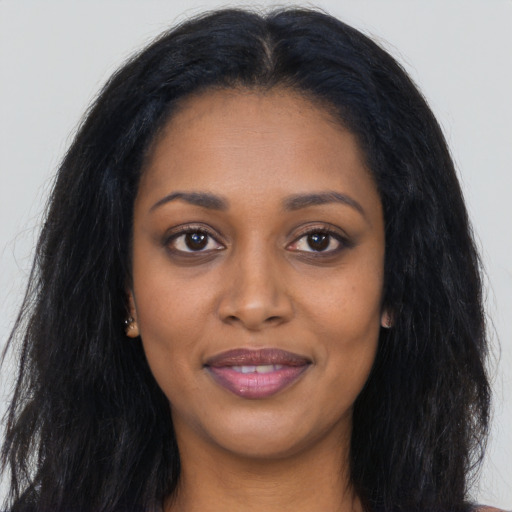 Joyful black young-adult female with long  black hair and brown eyes
