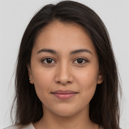 Joyful latino young-adult female with long  brown hair and brown eyes