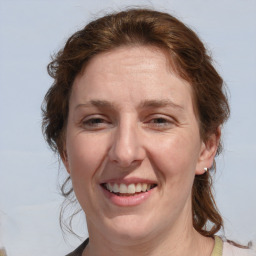 Joyful white adult female with medium  brown hair and blue eyes