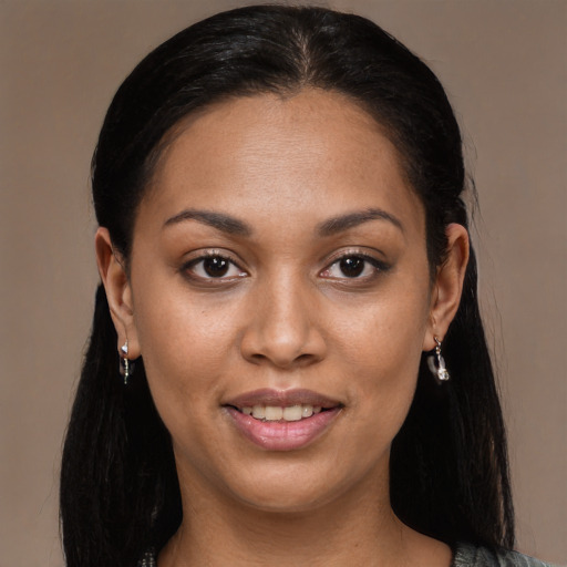 Joyful black young-adult female with long  black hair and brown eyes