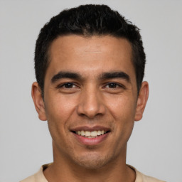 Joyful white young-adult male with short  black hair and brown eyes