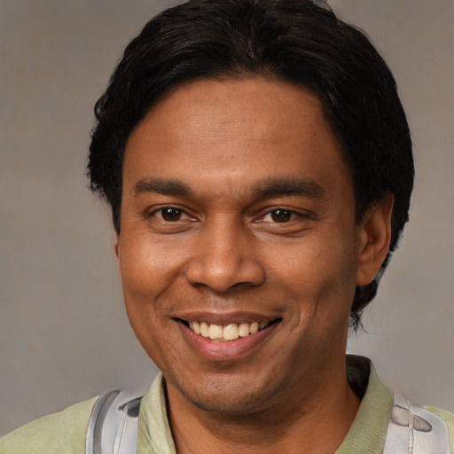 Joyful latino adult male with short  black hair and brown eyes