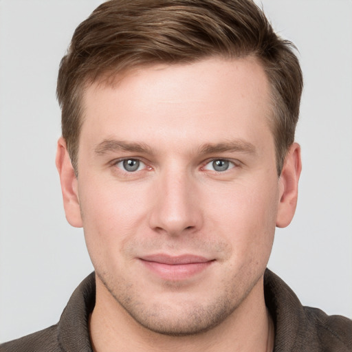 Joyful white young-adult male with short  brown hair and grey eyes