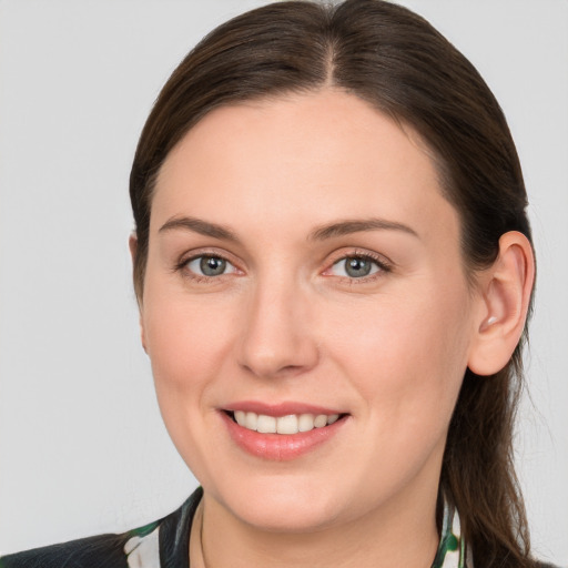 Joyful white young-adult female with medium  brown hair and grey eyes