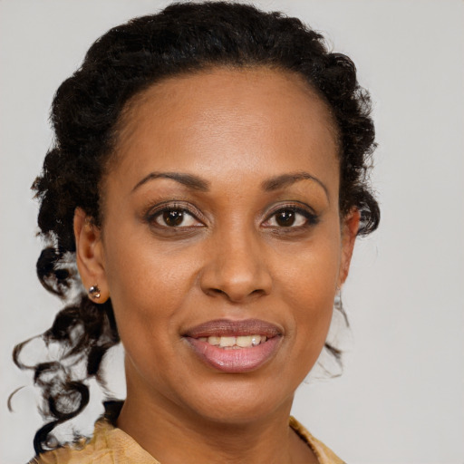 Joyful black adult female with medium  brown hair and brown eyes