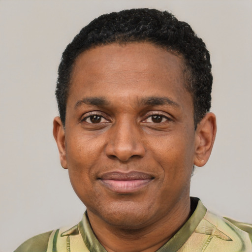 Joyful black adult male with short  black hair and brown eyes
