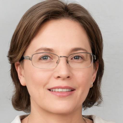 Joyful white adult female with medium  brown hair and blue eyes