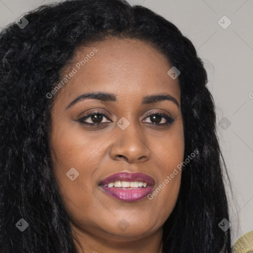 Joyful black young-adult female with long  brown hair and brown eyes