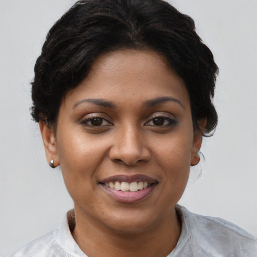 Joyful black young-adult female with short  brown hair and brown eyes