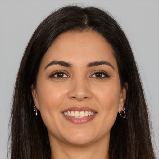 Joyful latino young-adult female with long  brown hair and brown eyes