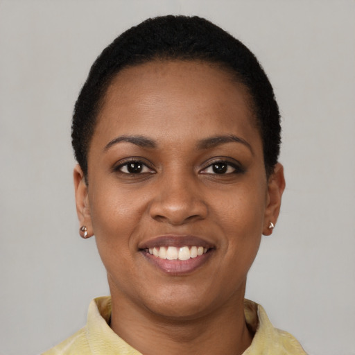Joyful black young-adult female with short  black hair and brown eyes