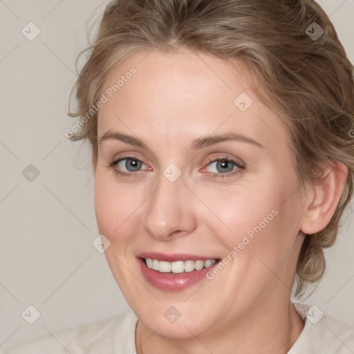 Joyful white adult female with medium  brown hair and blue eyes