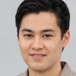 Joyful asian young-adult male with short  brown hair and brown eyes