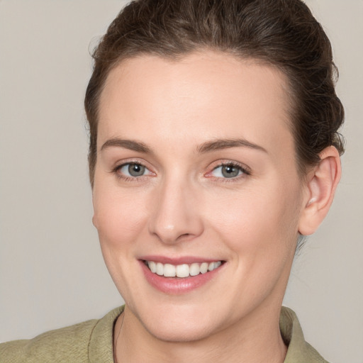 Joyful white young-adult female with short  brown hair and grey eyes