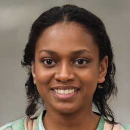 Joyful black young-adult female with medium  brown hair and brown eyes