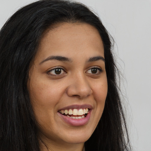 Joyful latino young-adult female with long  brown hair and brown eyes