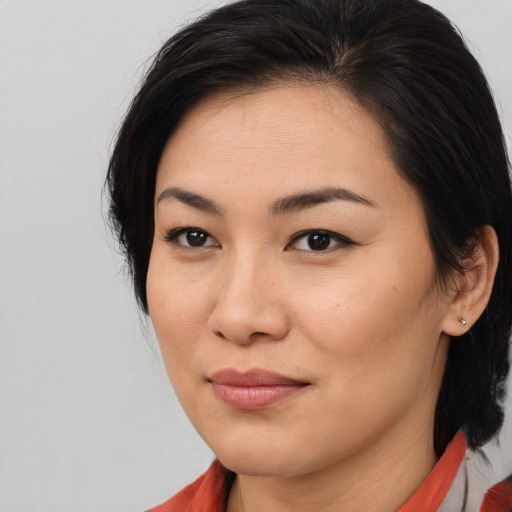 Joyful asian young-adult female with medium  brown hair and brown eyes