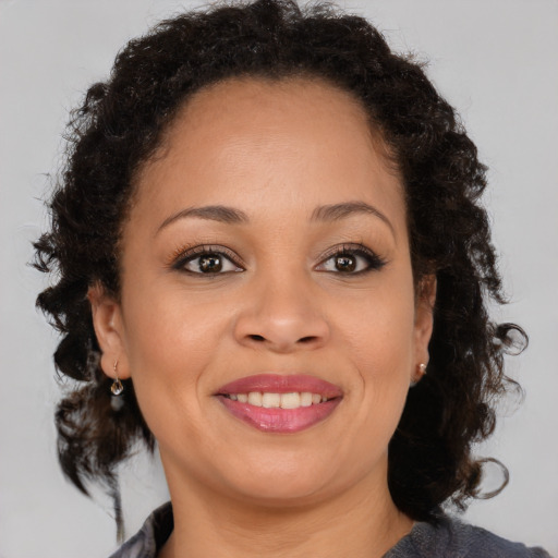 Joyful black adult female with medium  brown hair and brown eyes