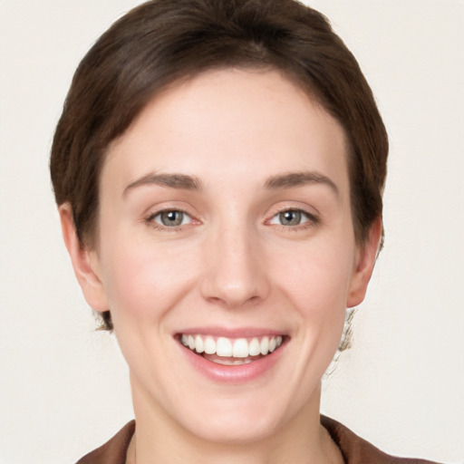 Joyful white young-adult female with short  brown hair and grey eyes