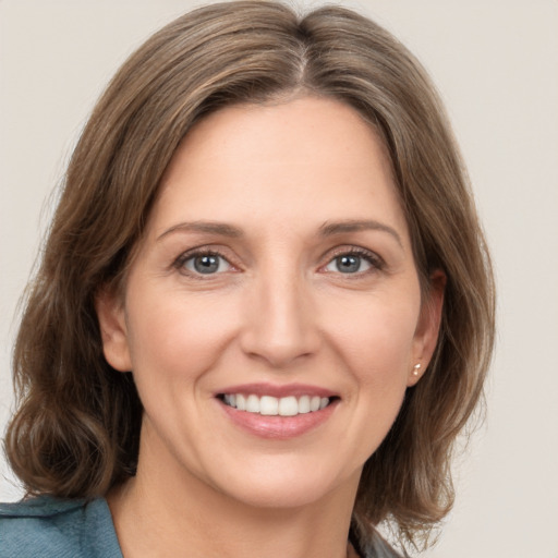 Joyful white young-adult female with medium  brown hair and grey eyes