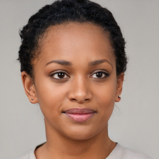 Joyful black young-adult female with short  brown hair and brown eyes