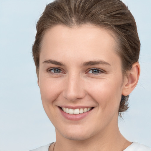 Joyful white young-adult female with short  brown hair and grey eyes