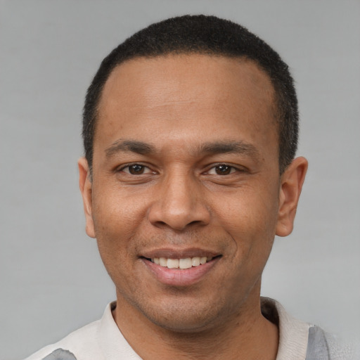 Joyful latino adult male with short  black hair and brown eyes