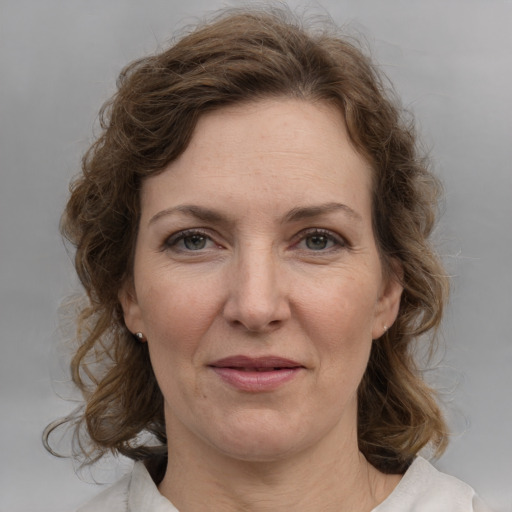 Joyful white adult female with medium  brown hair and grey eyes