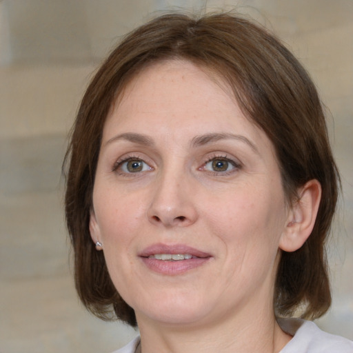 Joyful white adult female with medium  brown hair and grey eyes