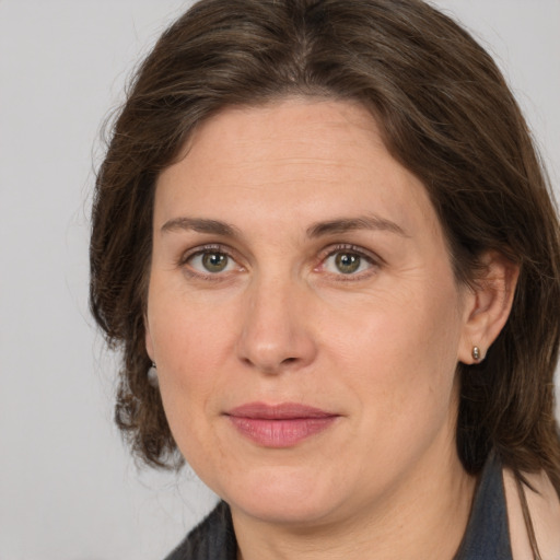 Joyful white adult female with medium  brown hair and grey eyes