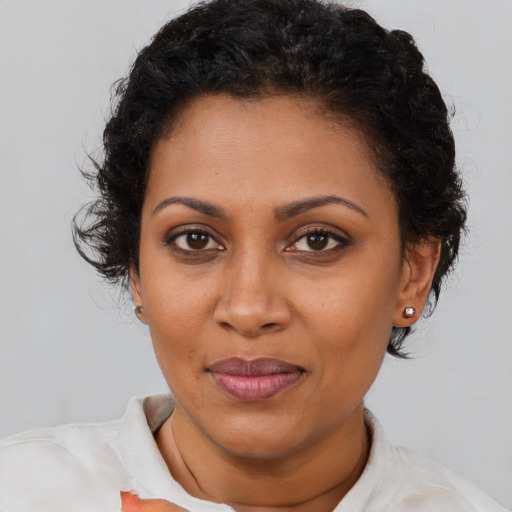 Joyful black young-adult female with short  brown hair and brown eyes