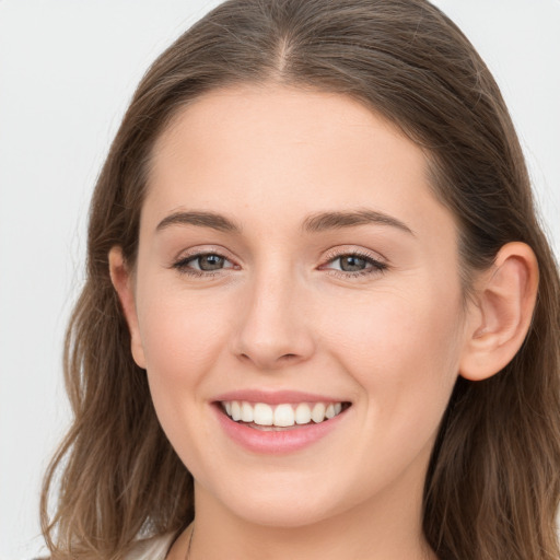 Joyful white young-adult female with long  brown hair and grey eyes