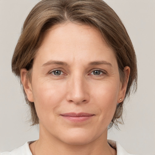 Joyful white adult female with medium  brown hair and brown eyes