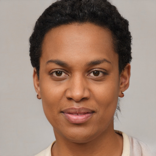 Joyful black young-adult female with short  black hair and brown eyes