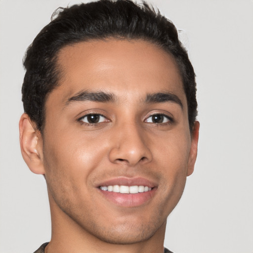 Joyful latino young-adult male with short  brown hair and brown eyes