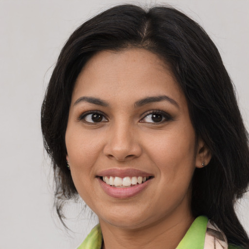 Joyful latino young-adult female with medium  brown hair and brown eyes