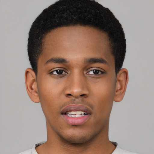 Joyful black young-adult male with short  black hair and brown eyes