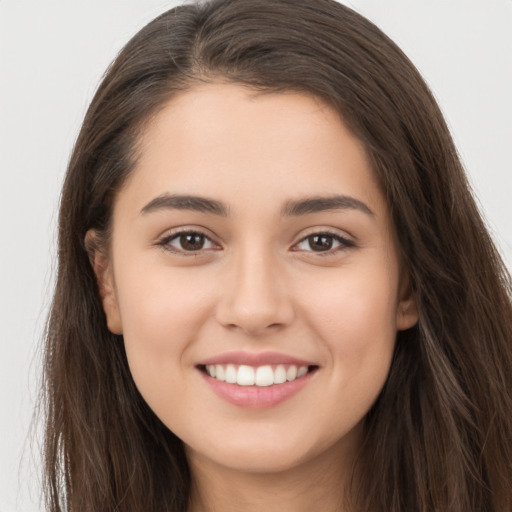 Joyful white young-adult female with long  brown hair and brown eyes