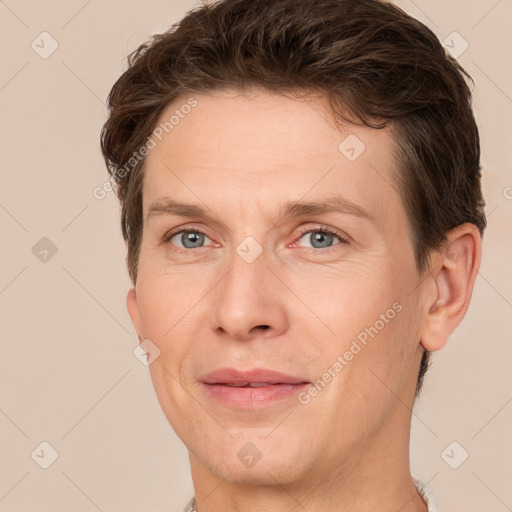 Joyful white adult male with short  brown hair and grey eyes