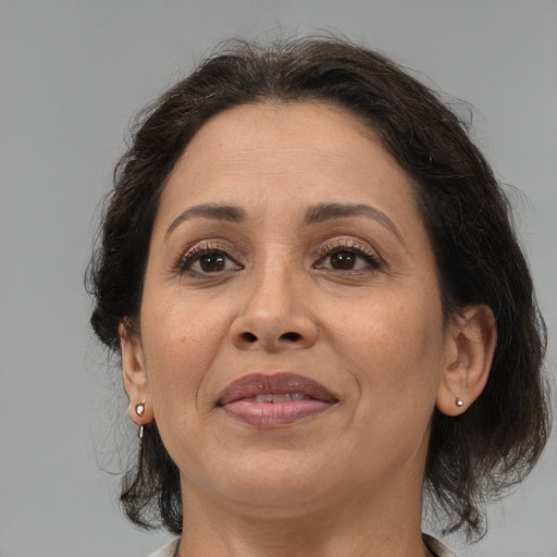 Joyful latino adult female with medium  brown hair and brown eyes