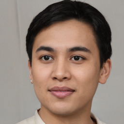 Joyful asian young-adult male with short  brown hair and brown eyes