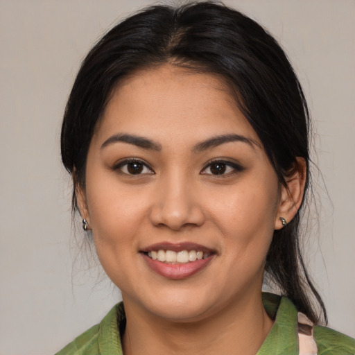 Joyful latino young-adult female with medium  brown hair and brown eyes