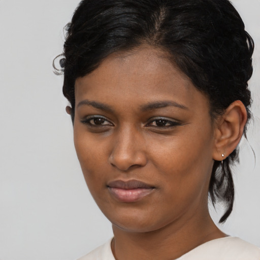 Joyful black young-adult female with medium  brown hair and brown eyes