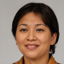 Joyful asian adult female with medium  brown hair and brown eyes